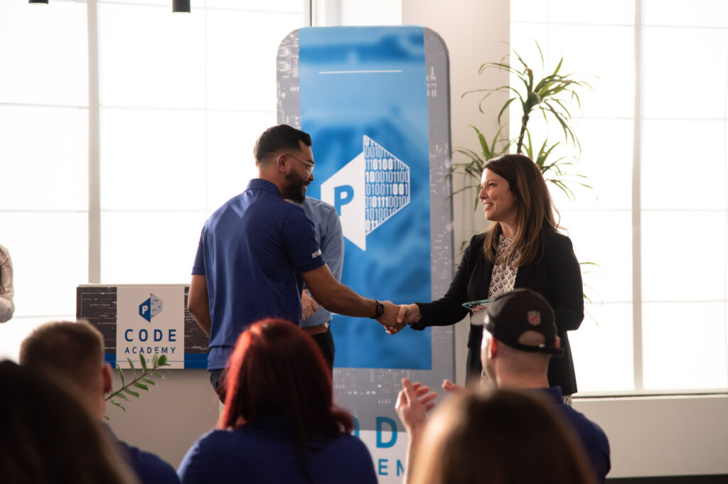 manager congratulates employee at work with a handshake 